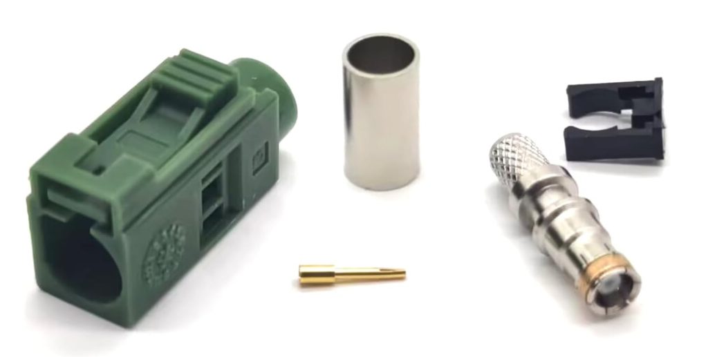 Disassembled components for FAKRA connector assembly including housing, pin, and ferrule ready for installation.